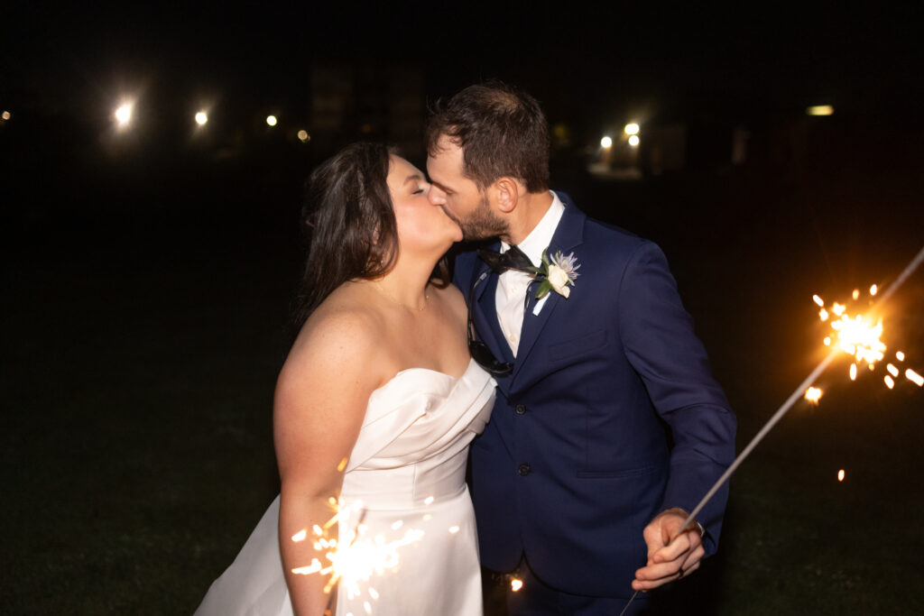 bride and groom kissing while holding sparklers at The Bibb Mill in Columbus Georgia by Amanda Richardson Photography